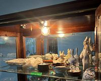 Overall view of cabinet shelf with porcelain and glass items