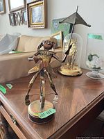 Front view of welded metal clown on unicycle music box with umbrella