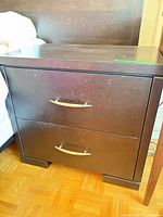 Front view of two-drawer nightstand showing overall design and handles