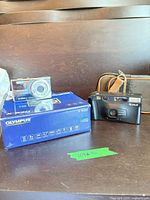 Olympus X-920 box, Olympus camera, Fujifilm camera with case in background