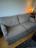 Front view of taupe-grey pullout couch with two back cushions and single seat cushion