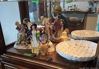 Group view of all figurines and bowls in cabinet