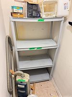 Full view of grey 4-tier plastic shelf inside closet