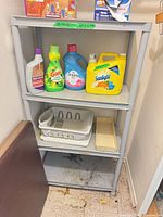Full view of 4-tier plastic shelf showing overall structure and contents for scale