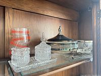 Shelf with four Pyrex cups, pressed glass sugar/creamer/tray, silver-plated casserole and small dish
