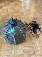 Entire swag lamp showing woven wicker shade, metal cap, chain and cord