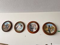 All four framed ceramic plates mounted on wall
