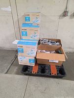 Stack of sealed KN95 mask boxes on pallet with two open cartons of bagged accessories