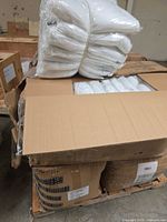 Pallet with three cartons, one open showing individually wrapped pillow inserts