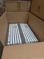 Open carton showing two trays of white keycaps