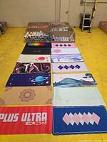 Rolled desk mats in cartons and samples laid out showing various designs