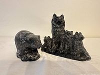 Both sculptures side by side, wolf with cubs and bear
