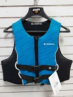 Front view of Legend blue/black life jacket on hanger showing zipper, buckle straps, brand logo, and attached tag