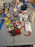 Overall lot showing candlesticks, vase, figurines, garland, metal figure and jewelry bag