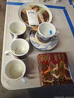 Group view: four mugs, stack of small plates, large plate, red lacquer box