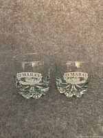 Front view of both glasses showing O'Mara's logos