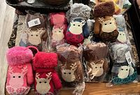 Overview of all 11 packaged mittens showing colours and reindeer motif
