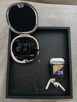 Overall lot showing both earphone sets, cases and sleeve