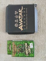 Avatar Legends dice box and Pathfinder Condition Cards front view