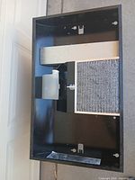overall view of black range hood showing light lens and mesh filter