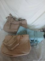 All three handbags arranged together to show overall condition and size comparison