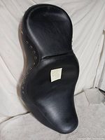 Full view of black Harley two-up seat showing eyelets and overall condition