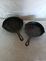 Two vintage cast iron skillets side by side