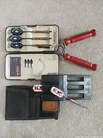 Overview of entire lot showing dart set in case, hand exerciser, spare dart holder and pouch