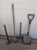 All four tools leaning against garage door