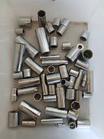 Top view of assorted deep and shallow chrome sockets in bin