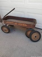 Full view of wagon showing body, handle, three mounted wheels, spare wheel