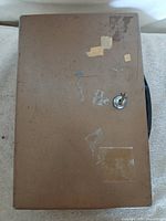 Top view of brown metal lockbox showing wear and carry handle