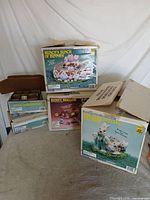 Stack of five Wee Crafts Easter paint kit boxes, one open box visible