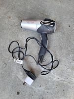 BaByliss Turbo Power 2200 hair dryer with cord and EU plug fitted with US adaptor displayed on floor