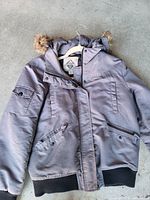 Front view of gray Beaver Canoe parka showing hood, faux fur trim, pockets, rib knit cuffs and hem