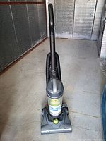 Overall front view of Bissell bagless upright vacuum with hose and power cord visible