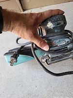 Overall view showing Bosch 1297D sander, grip, power cord, dust box