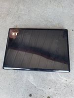Closed laptop showing glossy black lid with HP logo