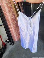Full view of white satin slip chemise held up, showing overall condition and length