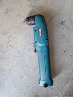 Full view of Makita right-angle corded drill showing teal body and keyless chuck