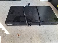 Top view of Samsung Blu-ray player showing overall condition, surface wear and attached power cord