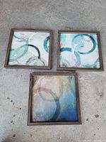 Three square wood-framed abstract prints