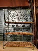 Front view showing three wicker shelves and decorative metal frame with heart and leaf motifs