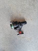 Top view of black plastic spincast reel with green monofilament line and reversible handle