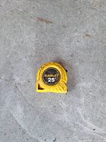 Front view of Stanley 25 ft yellow tape measure showing wear
