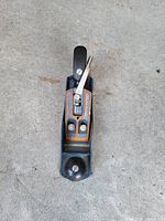 Top view of unbranded blue cast iron bench smoothing plane with blade, lever cap, black knob and tote
