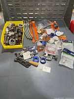 Full lot overview showing supply lines, fittings, tools, washers, packaged parts
