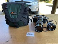 Lot overview showing bag, camera with 200 mm lens, 50 mm lens, filter