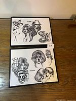 Both framed tattoo flash prints side by side on table