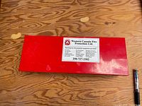 Closed red steel box with Western Canada Fire Protection Ltd. label visible
